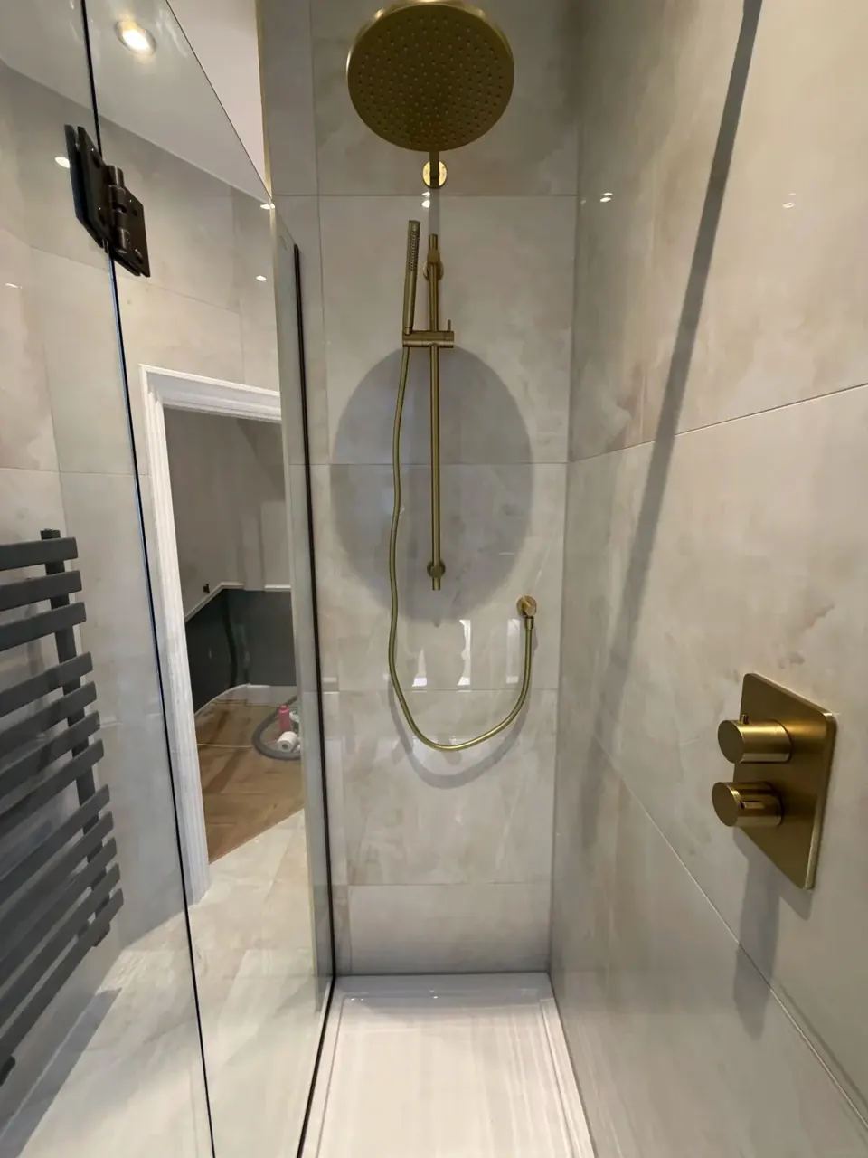 Completed walk-in shower with brushed metal fittings